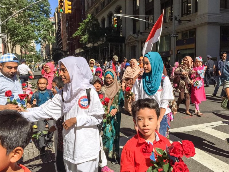 anak-anak yang membagikan bunga saat pawai. gambar via: GNFI